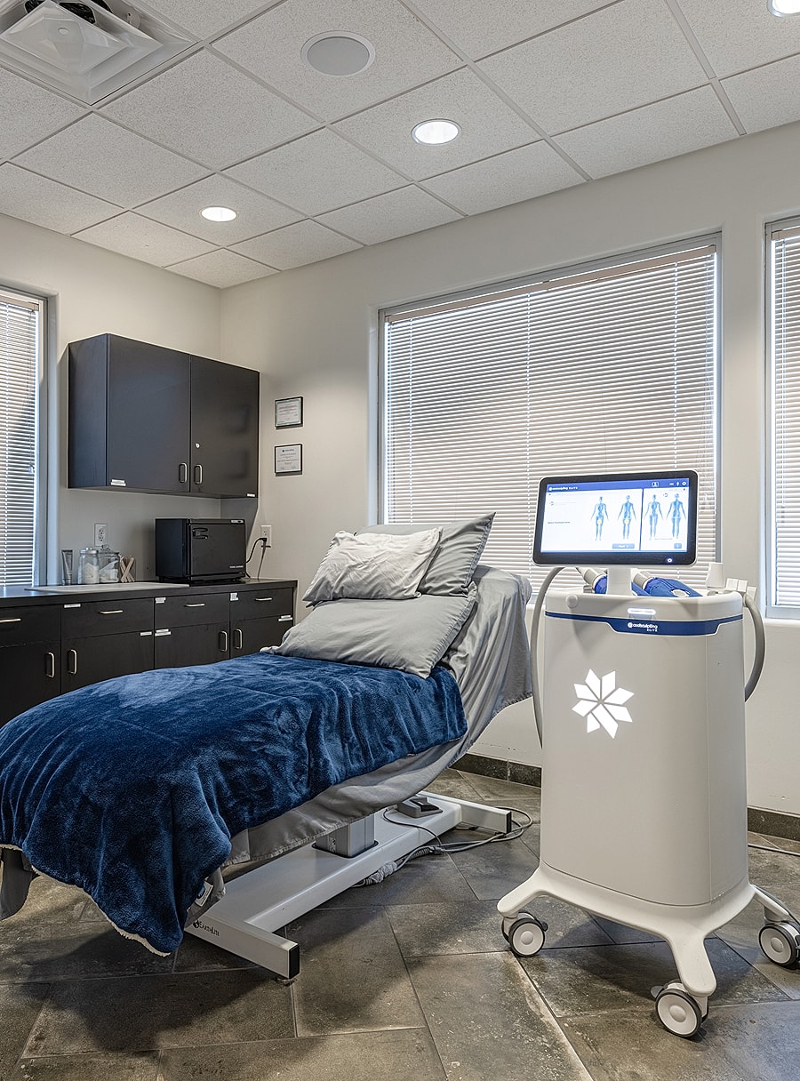Medical treatment room with bed and equipment.