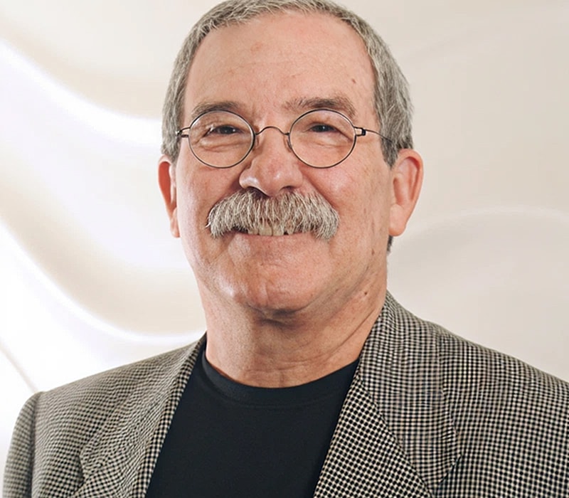 Smiling man with glasses and a mustache.